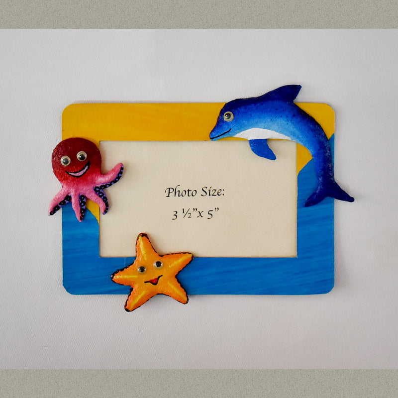 A rectangular Magnetic Photo frame exquisitely  handmade with paper pulp  designs - Dolphin, Octopus and a Starfish all 3 smiling.